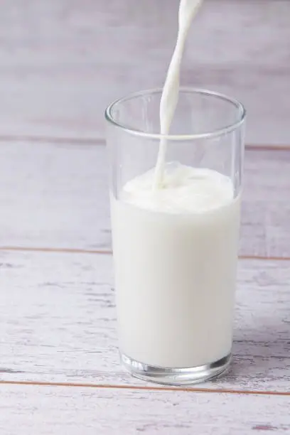Fill glass milk. White drink. Light background.