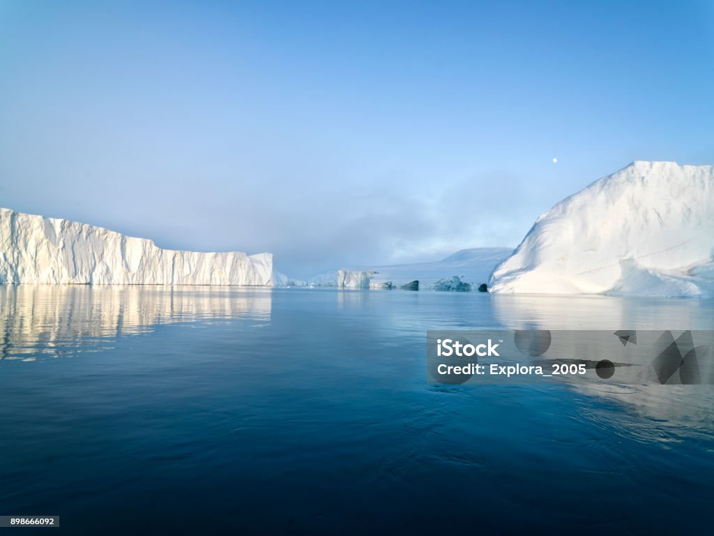 Arctic Icebergs on Arctic Ocean in Greenland Arctic Icebergs Greenland in the arctic sea. You can easily see that iceberg is over the water surface, and below the water surface. Sometimes unbelievable that 90% of an iceberg is under water Arctic Ocean Stock Photo