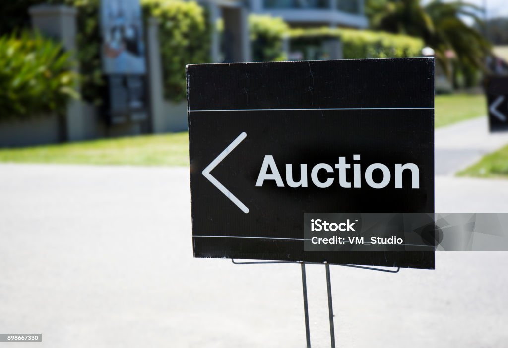 Auction sign Auction sign, outside suburban home, positioned on front lawn. Auction Stock Photo