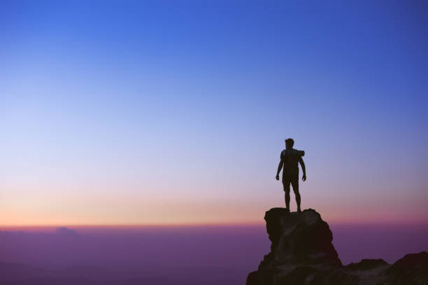 Man's silhouette on background of sunset sky stock photo