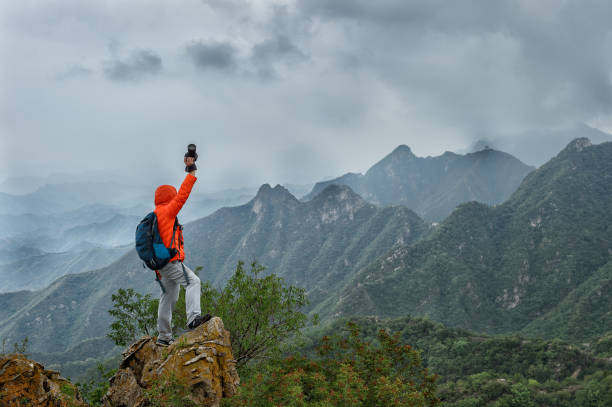 istock Strong mountain climber standing on the summit of a peak 898676486