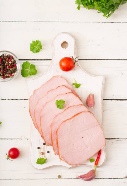 Slices of ham on white wooden background. Flat lay. Top view Slices of ham on white wooden background. Flat lay. Top view beef pad stock pictures, royalty-free photos & images