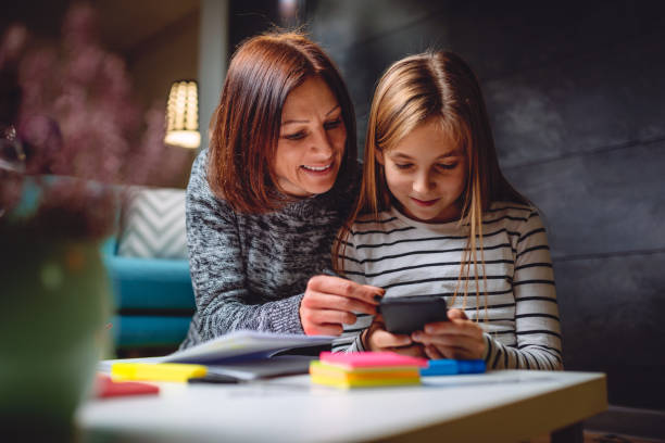 istock Mother and daughter using smart phone 898680382