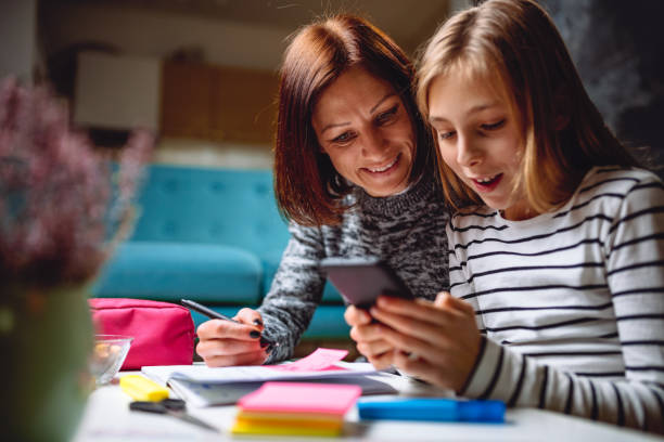 madre e hija con teléfono inteligente - child digital tablet mother teaching fotografías e imágenes de stock