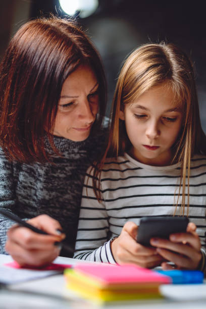 madre e hija con teléfono inteligente - child digital tablet mother teaching fotografías e imágenes de stock