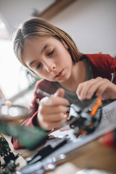 istock Girl building a robot at home 898684232