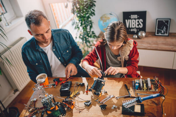 istock Father and daughter building robot 898687944