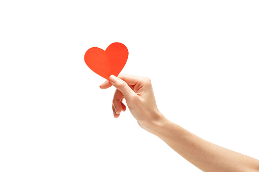 red paper heart in hand isolated on white