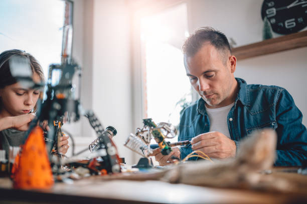 istock Father and daughter building robot 898692016