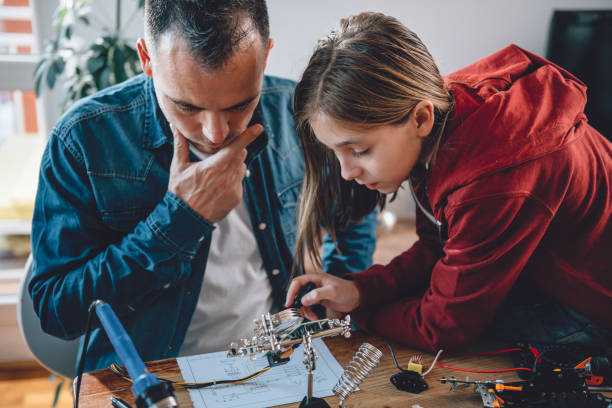 istock Father and daughter looking at electronic schematics 898692630