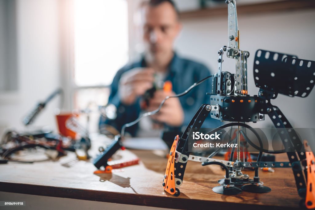 Diy project Diy robot project on table in background man working in his home office Laboratory Stock Photo