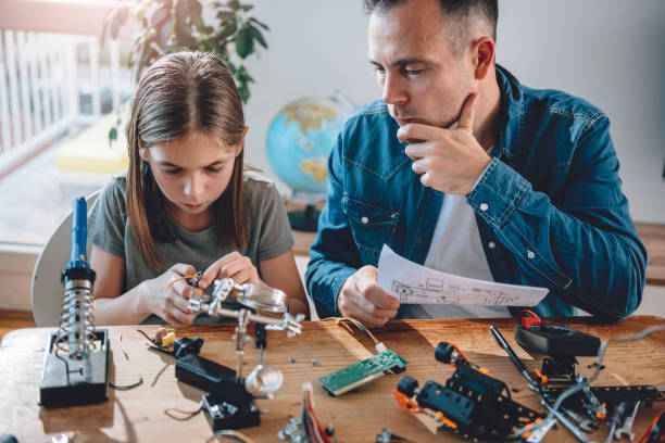istock Father and daughter building robot 898696106