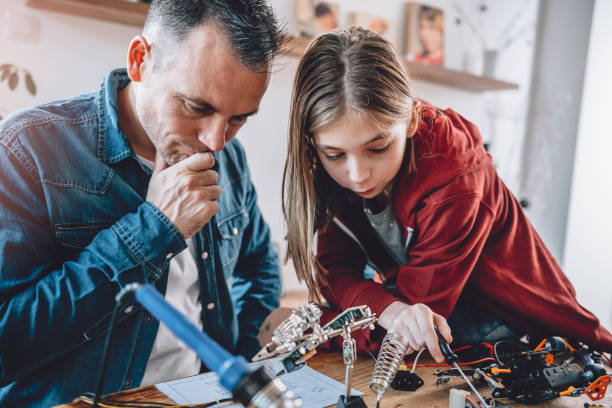 istock Father and daughter looking at electronic schematics 898696284