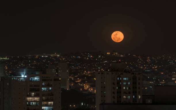 istock Full moon night goes up the city 898696440