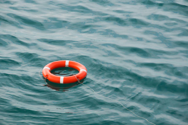 life preserver floating on the sea orange lifebuoy on the waves as the concept of salvation lifeguard stock pictures, royalty-free photos & images