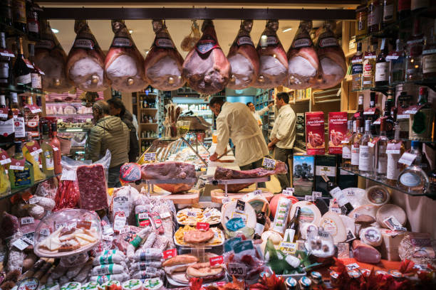 Rome, Italy - December 2, 2017: Illuminated Meat Shop window in the Rome on the evening. Both butchers and customer can be seen in the shop.