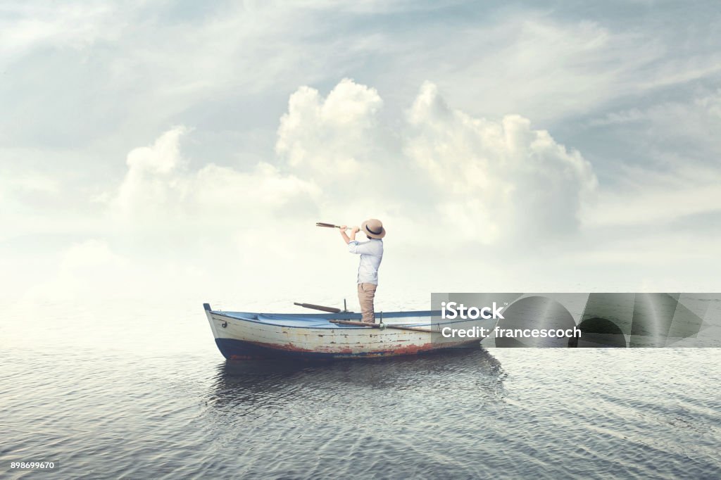 hombre de negocios en un barco mirando el futuro con binoculares - Foto de stock de Embarcación marina libre de derechos