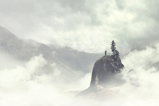 hombre de la cima de la montaña en la niebla photo