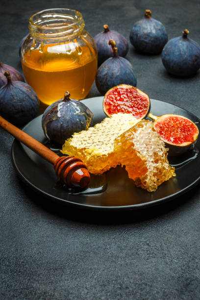 istock Figs with honey on in the plate on dark concrete background 898703626