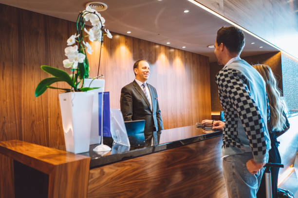 istock Hotel receptionist checking couple in 898707404