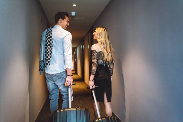 istock Couple smiling at each other while going to the hotel room 898708628