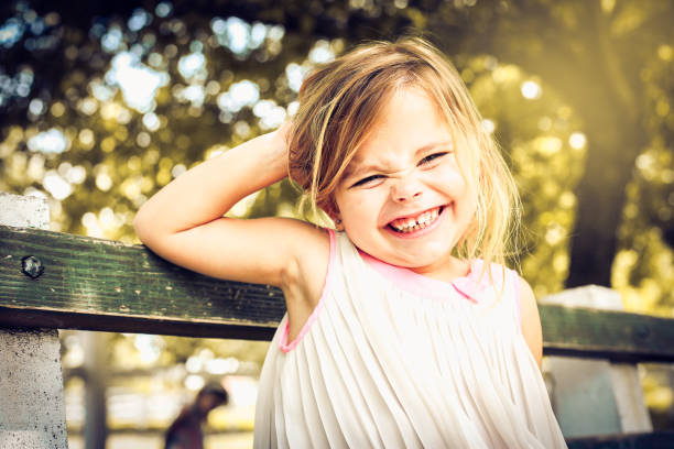 Funny little girl sitting in the park.
