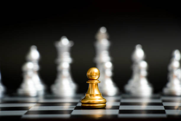 istock Gold pawn in chess game face with the another silver team on black background (Concept for company strategy, business victory or decision) 898716382