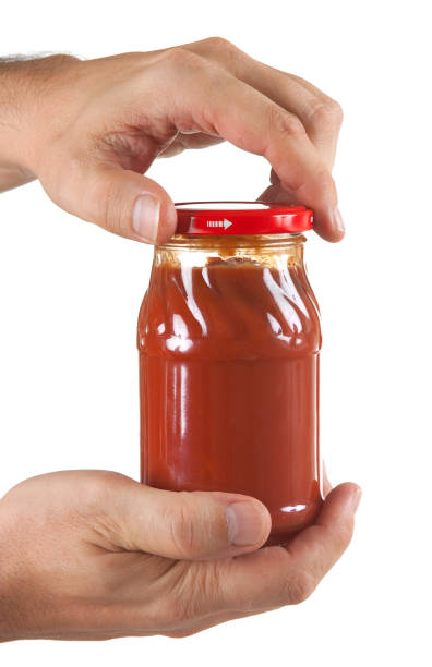 recipiente de pasta de tomate en la mano - relish jar condiment lid fotografías e imágenes de stock