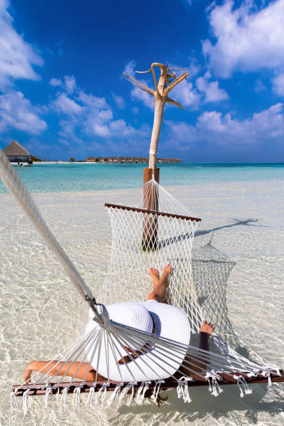 istock Woman with white hat relaxing on a hammock 898731464