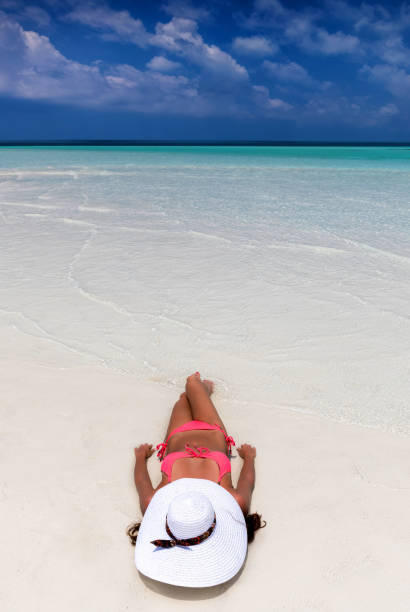 istock Attractive woman is taking a sunbath on a beach 898732150