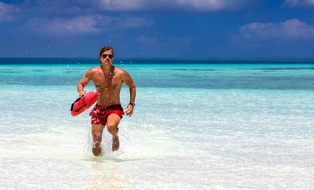 bagnino che corre in acque turchesi - lifeguard swimming pool summer swimming foto e immagini stock