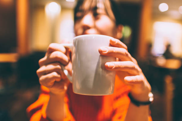 A young Japanese woman is enjoying drinking a cup of coffee in a cafe in Tokyo.