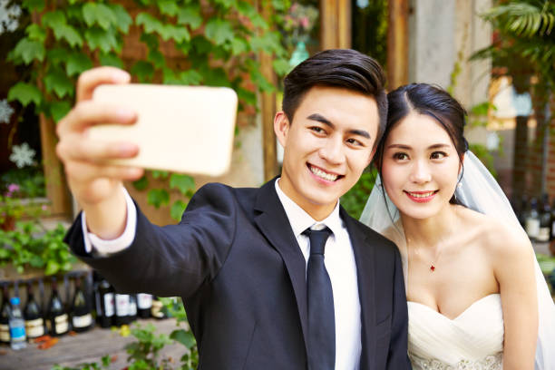 istock asian newlywed taking a selfie 898741538