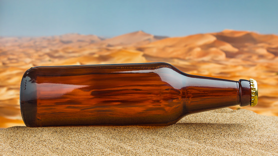 bottle of beer in desert on the hot sand
