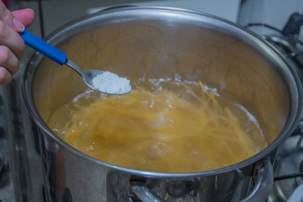 istock Pouring salt for cooking pasta 898748544