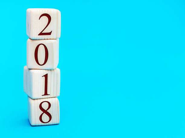 istock Stack of wooden cubes with numbers 2018 on blue. New year 2018 concept. 898753176