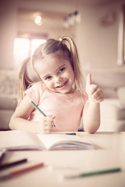 istock Little girl drawing and showing ok.  Inside. 898753968
