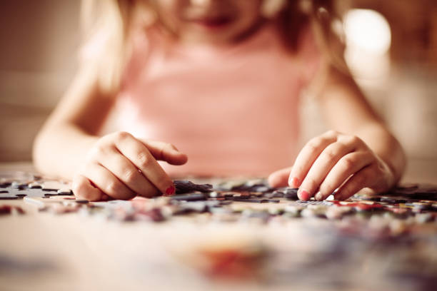 istock Girl playing puzzle. Focus on hands. 898756902