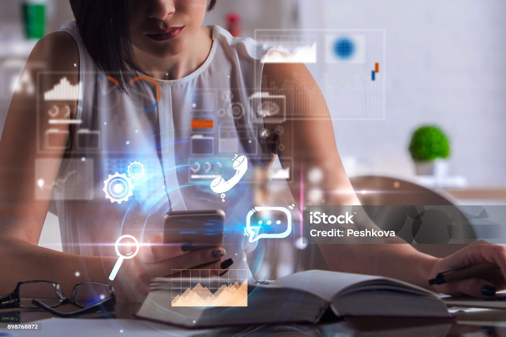 Network and communication concept Businesswoman using smartphone with digital business interface at workplace with book and supplies on blurry background. Network and communication concept. Double exposure Multiple Exposure Stock Photo
