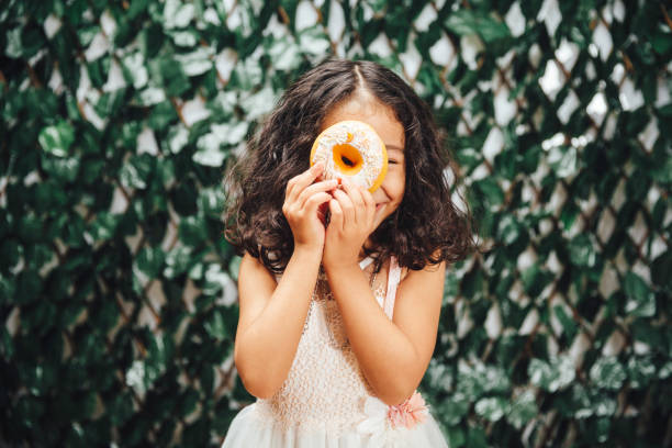 Little girl with donuts in front of her eyes