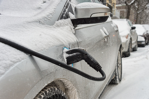 Montreal, Canada - 12 December 2017: Electric car getting charged in Montreal during snowstorm