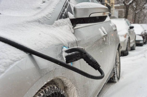 Electric car getting charged in Montreal during snowstorm stock photo