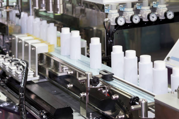 istock white plastic bottle on factory line machine in the factory, selective focus. 898773500