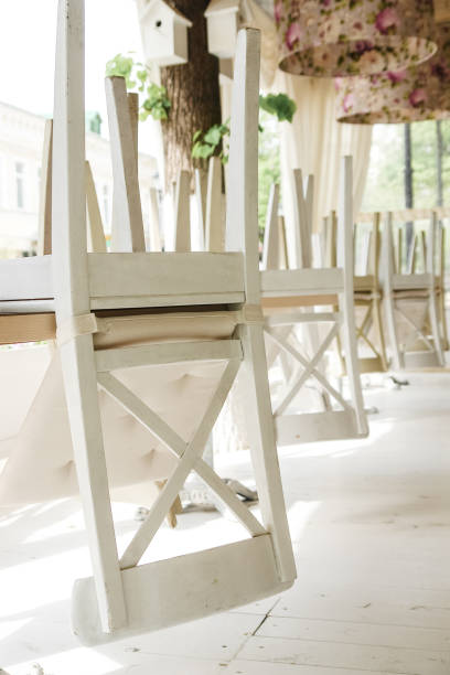 istock White chairs on tables upside down on street cafe summer terrace. 898777374