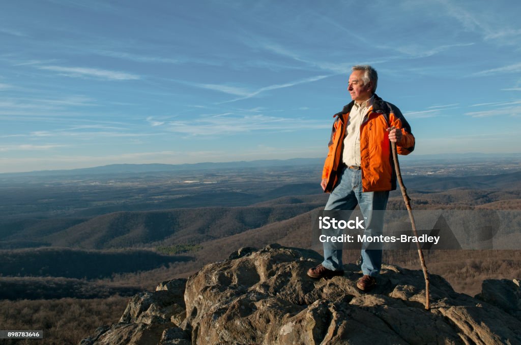 Grandpa Kink of the Hill A white Spanish-Latino man on to of the mountain scrutinizing the horizon. Hiking Stock Photo