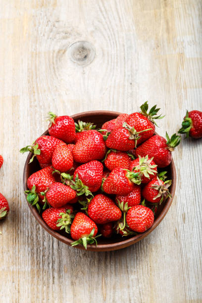istock Fresh strawberry in a clay plate  on wooden table 898784612