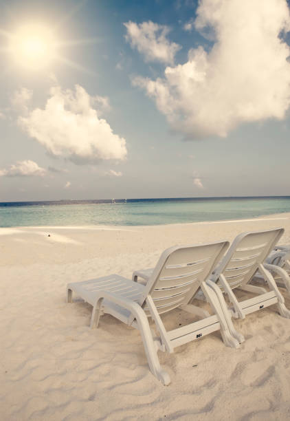 istock Empty beach chairs on sand by the sea , retro effect 898786326