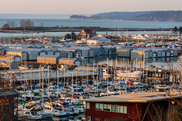 Overlooking Port Gardner Everett December, 2017 - a sunset view of Port Gardner Everett Washington. Boat storage and building glow in the reddish sunset as the Puget Sound water shows in the background. everett washington state stock pictures, royalty-free photos & images