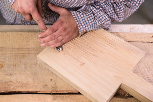 istock Carpenter at work. Working on wooden cutting board 898792548
