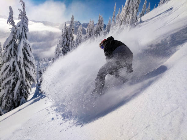 snowboard polvere neve spray soleggiato winter day allo stevens pass washington - sunny day mountain mountain range winter foto e immagini stock